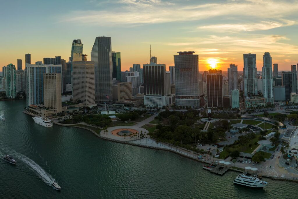 Vista aérea del distrito Brickell en Miami al atardecer, con rascacielos modernos y horizonte urbano iluminado.