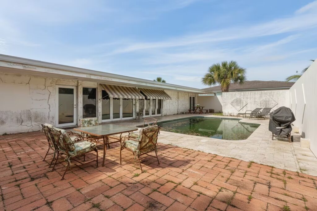 Old house with a deteriorated swimming pool—pre-renovation scene documenting an architectural restoration and value-add project.