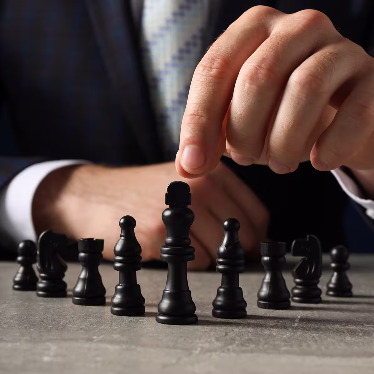 Man in a black suit contemplating a chessboard—symbolizing ARCSA CAPITAL’s institutional strategy, risk governance, and predictable returns in Miami.