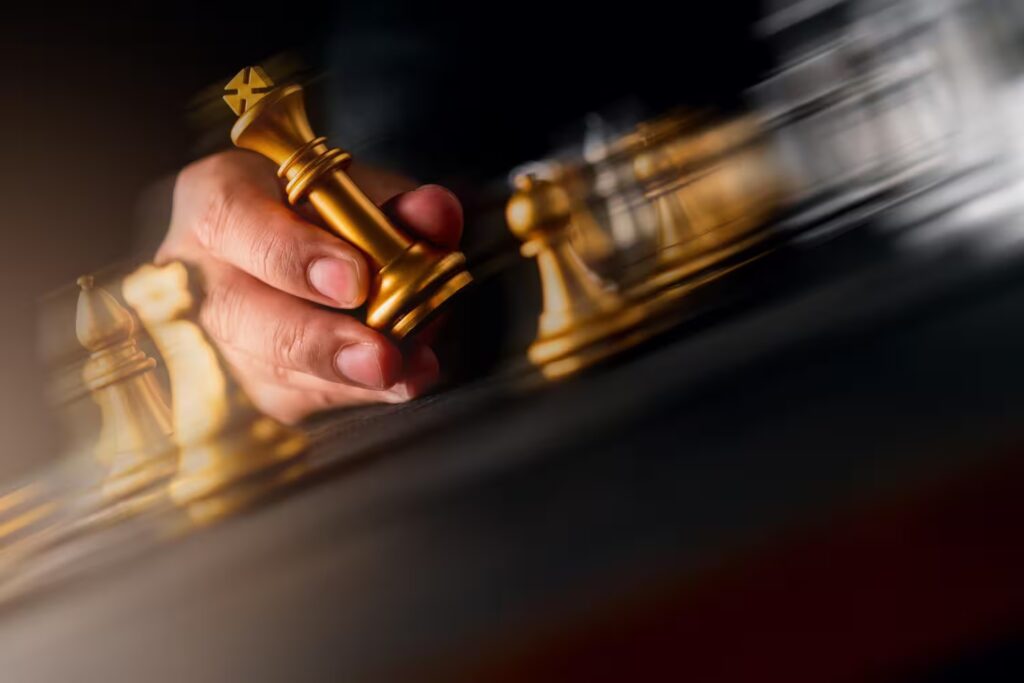 Hand moving a golden chess piece on a board—symbol of strategy, leadership, and disciplined corporate planning.