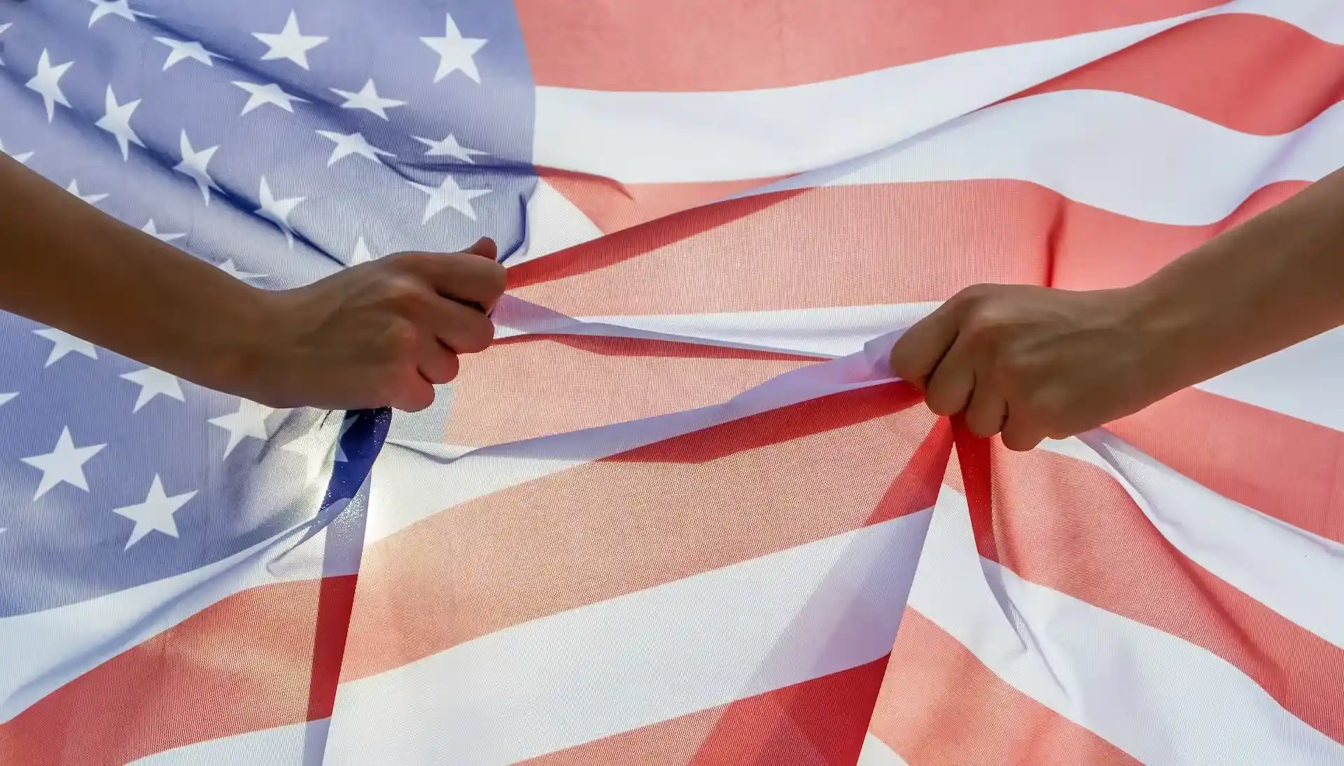 Hands holding the United States flag symbolizing Miami’s secure jurisdiction, fiscal benefits, and ARCSA CAPITAL’s institutional advantages for Latin American investors