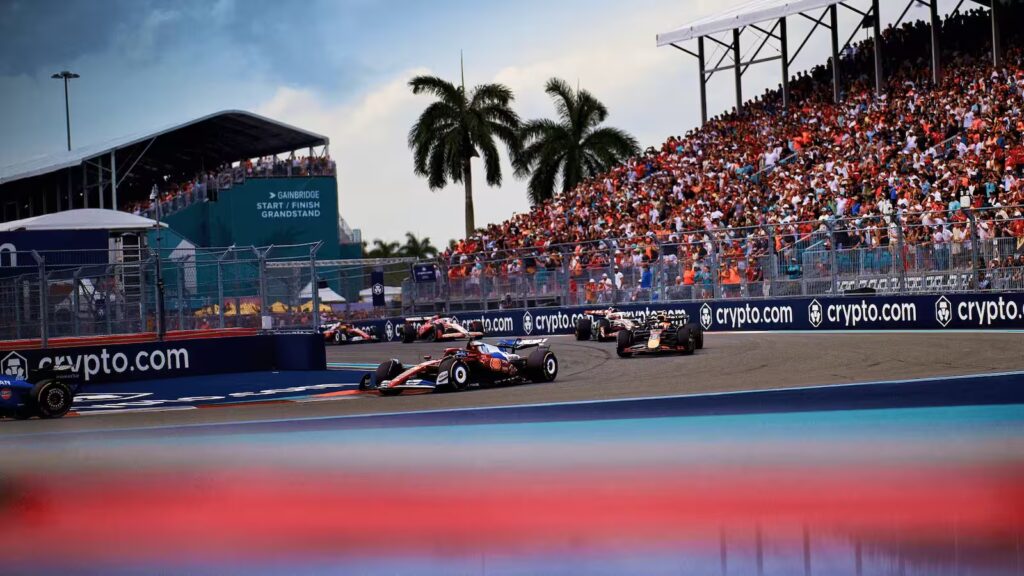 Miami Grand Prix corner battle with packed grandstands and race cars