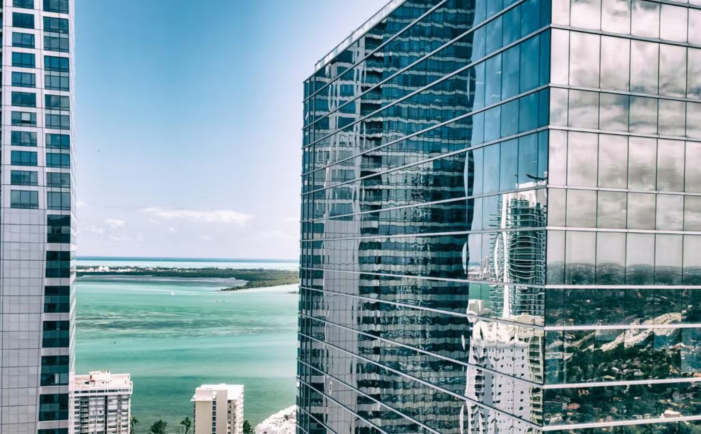Waterfront luxury skyline in the financial district—bayfront towers and premium real estate framed by palm trees at golden hour.