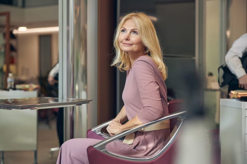 Confident professional woman reviewing data on a tablet in a modern, luxury setting.