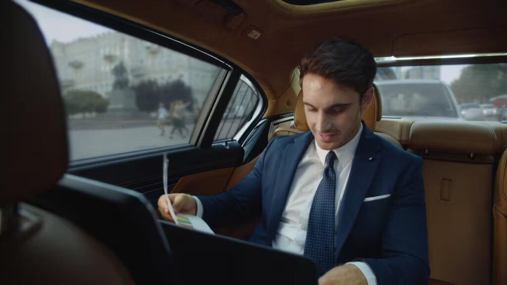 High-net-worth investor reviewing financial charts in a luxury vehicle.