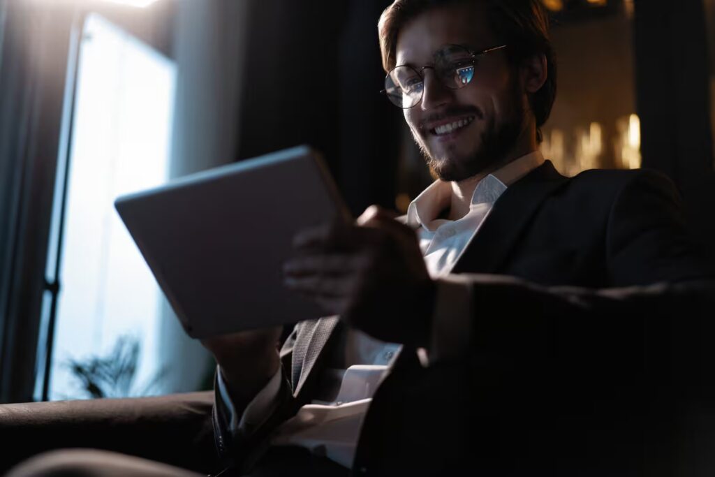 Investor smiling while reviewing successful returns on a tablet in a luxury setting. Real Estate Investment for Foreigners